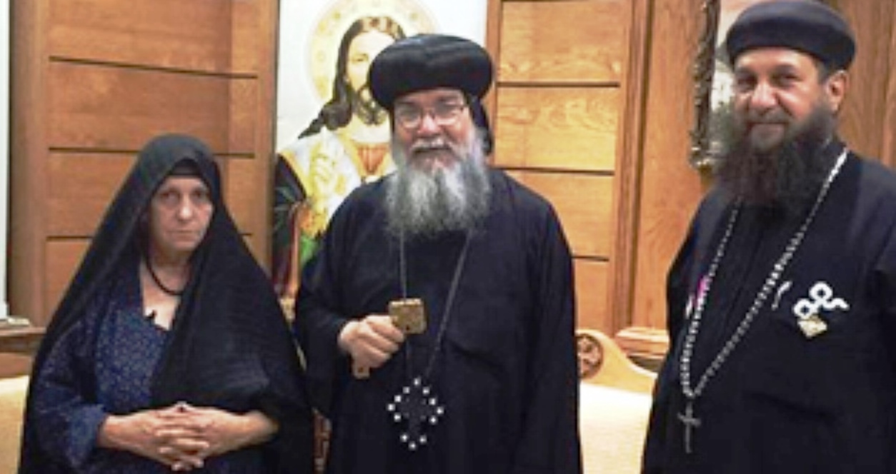 Bishop Makarious (center) stands with 70-year-old Christian woman who in an earlier attack was stripped naked, beat, and paraded in front of 300 jeering Muslims.